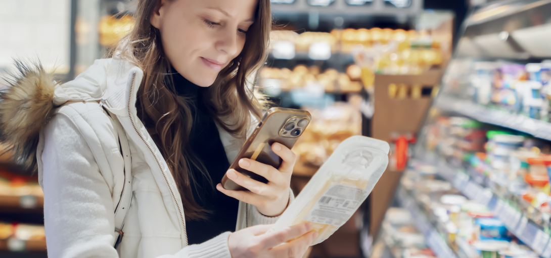 woman in supermarket scanning qr code on product label